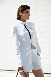 Woman wearing a white outfit with a black top against a white background